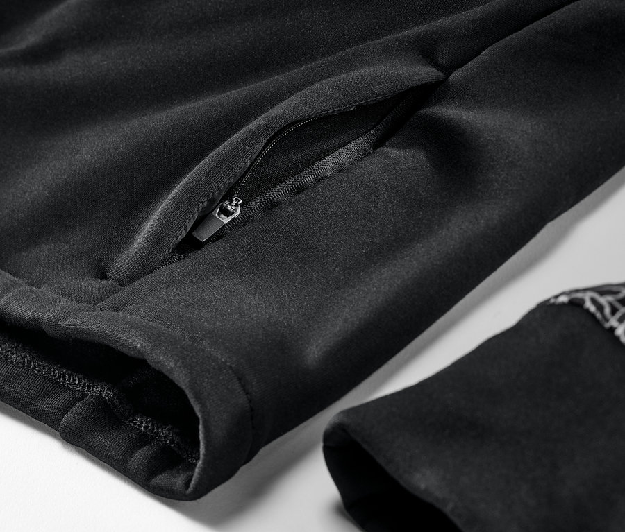 Detailaufnahme einer schwarzen Thermojacke mit Reißverschlusstasche und Ärmelbündchen.
