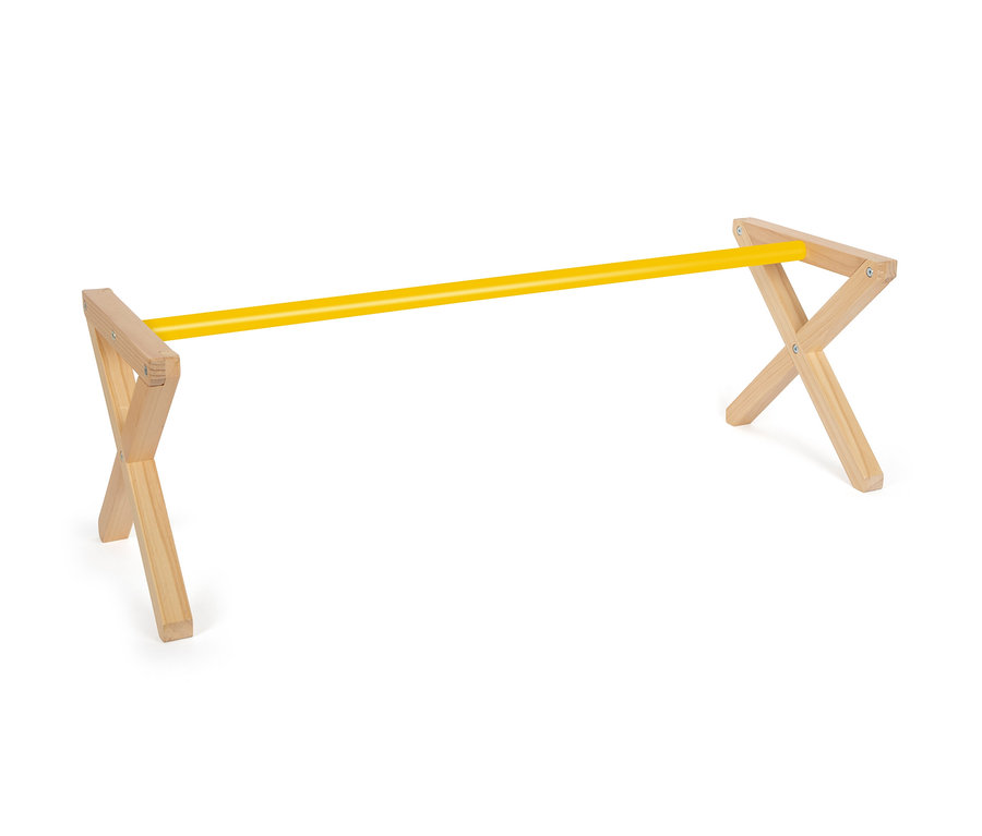 Ein gelber Stab liegt auf einem Hindernisbock aus Holz.
