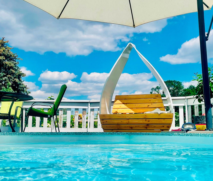 Am Pool stehen ein Tisch mit Stühlen und eine Wings for Living Sitzbank »San Francisco Twin«.