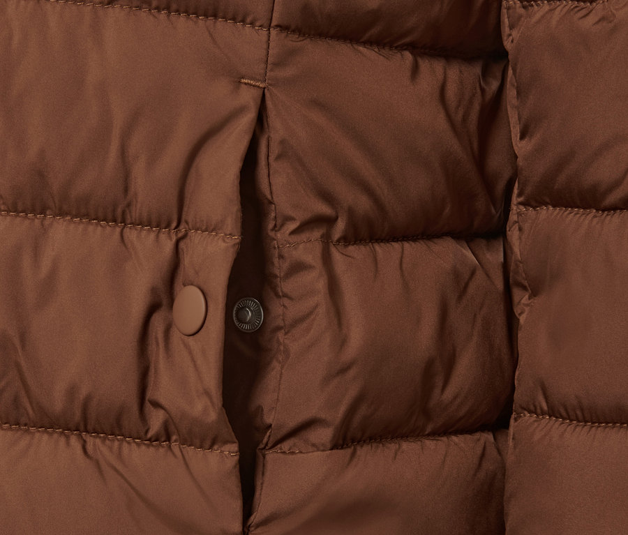 Detailansicht einer cognacfarbenen Steppjacke mit Kapuze.