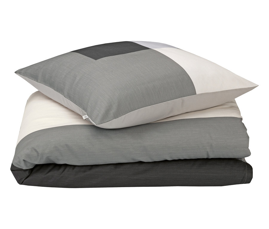 Ein gefaltetes Bettwäsche-Set mit einem Kissenbezug in einem geometrischen Design in Grau- und Weißtönen.