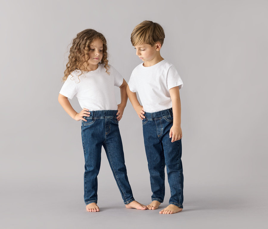 Zwei Kinder posieren in weißen T-Shirts und dunkelblauen Kinder-Pull-on-Pants – Fit »Luca«.