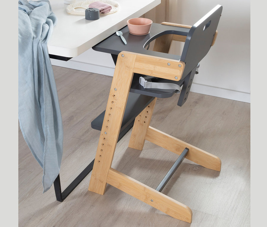 Ein anthrazitfarbener roba Babyhochstuhl steht neben einem Tisch.