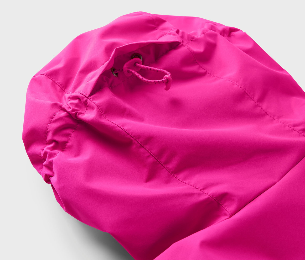 Detailansicht der Kapuze einer pinkfarbenen Jacke mit Kordelzug.