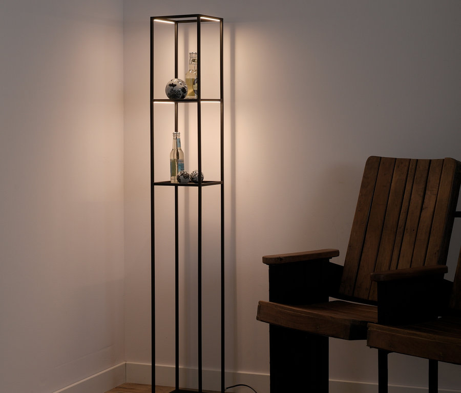 Eine schwarze Lampe mit Regalen und ein Holzstuhl stehen in einer Ecke des Zimmers.