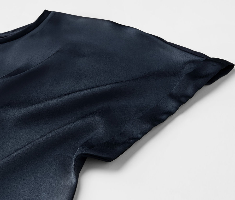 Detailansicht eines marineblauen Blusenshirts im Materialmix.