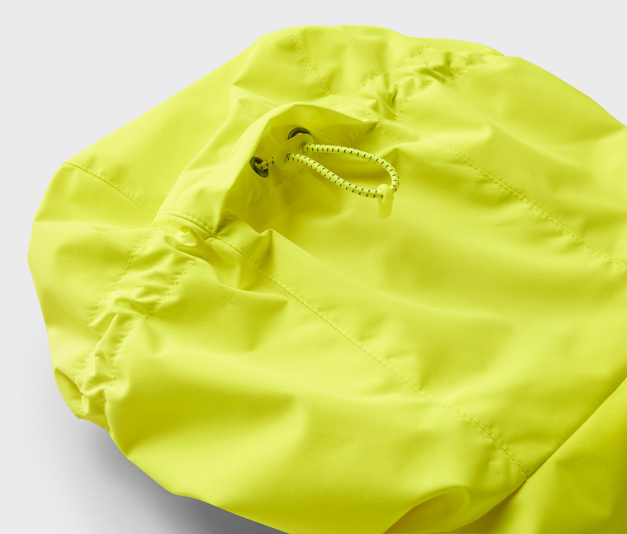 Detail einer gelben Jacke mit Kordelzug.