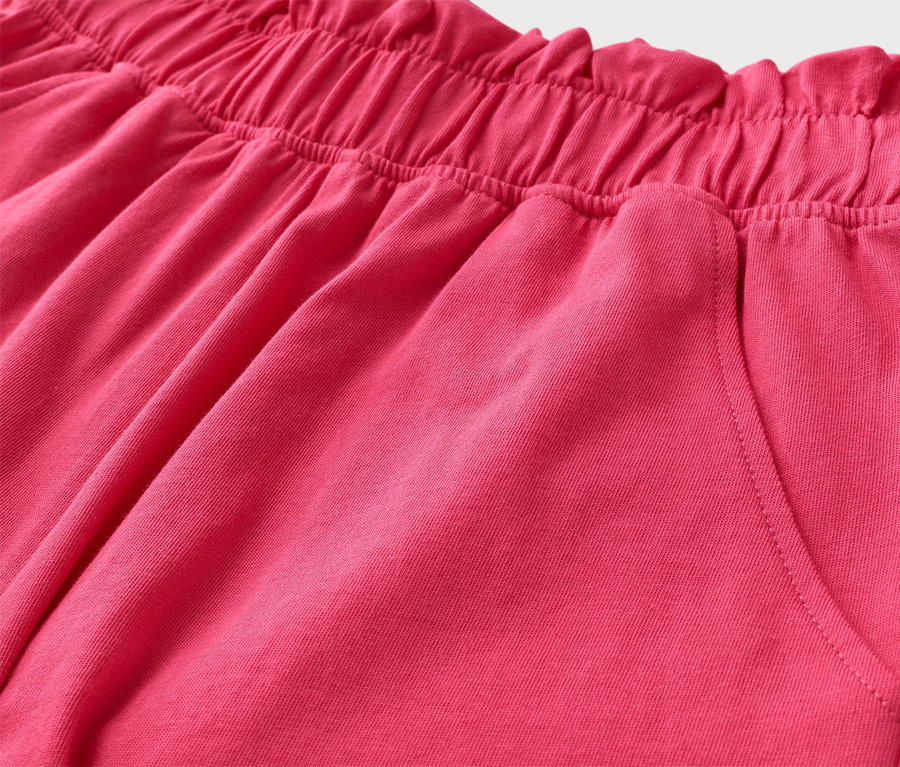 Nahaufnahme von pinken Shorts mit elastischem Bund und einer Tasche.