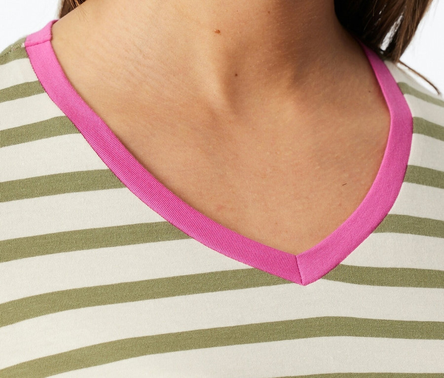 Nahaufnahme einer Frau, die ein gestreiftes Oberteil mit pinkfarbenem V-Ausschnitt trägt.