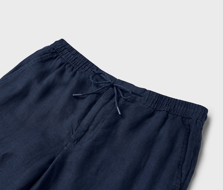 Detailansicht einer marineblauen Leinenhose mit Kordelzug.