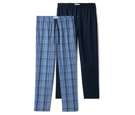 Zwei lange Schlafanzughosen, eine blau kariert, eine dunkelblau, liegen nebeneinander.