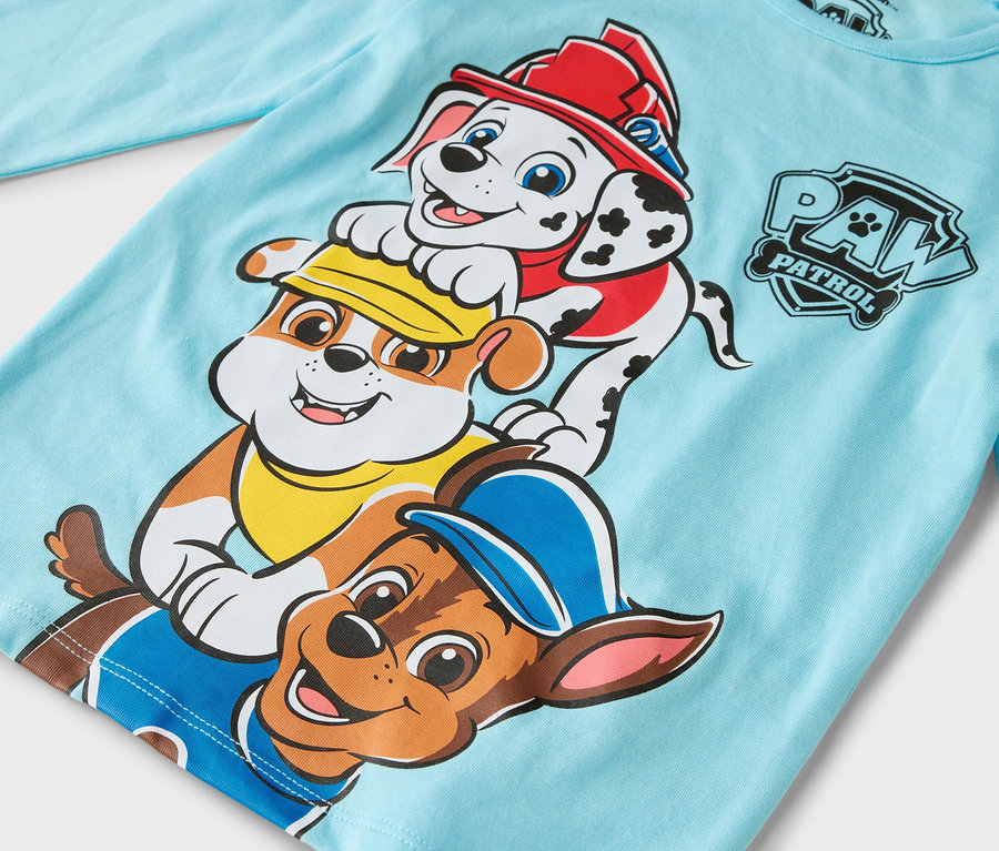 Auf dem hellblauen Langarmshirt sind die Paw Patrol Charaktere Marshall, Rubble und Chase abgebildet.
