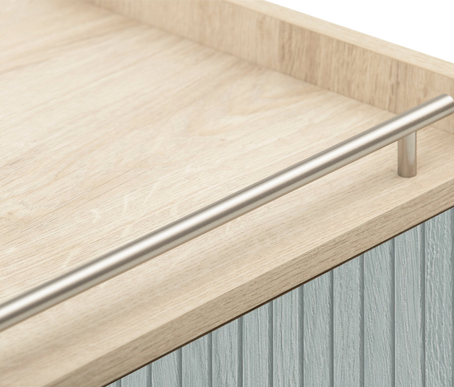 Detailansicht eines hellbraunen Holzschranks mit einer Schublade mit blauer Holzvertäfelung und einem silbernen Griff.