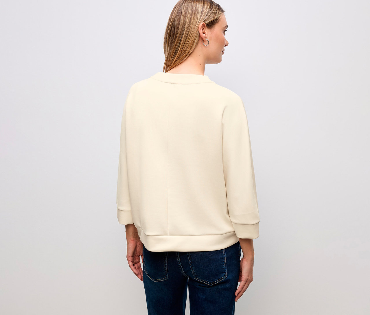 Rückansicht einer Frau mit blonden Haaren, die ein Street One T-Shirt aus Modalmix und Jeans trägt.