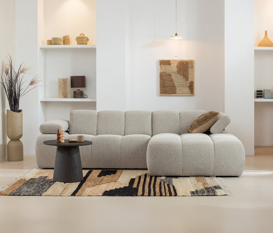 Wohnzimmer mit beigem Sofa und braun gemustertem Woood Teppich »Liberal«, 170 x 240 cm. Runder Tisch mit Deko.