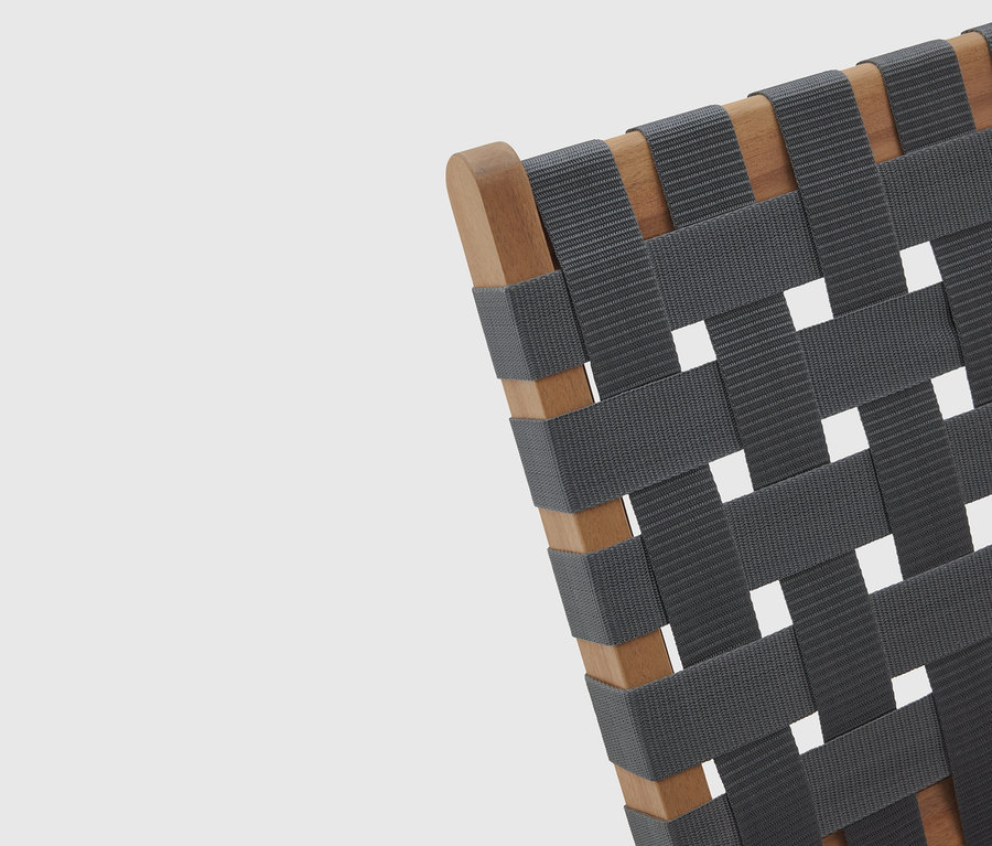 Detailansicht eines Stuhls mit Holzrahmen und gewebter, grauer Sitzfläche.