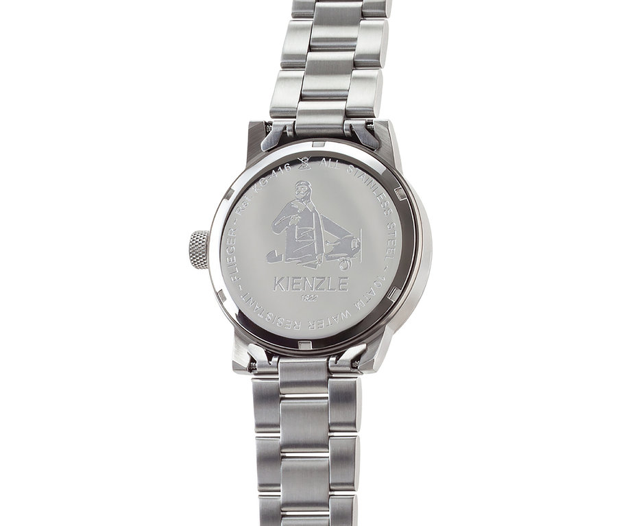 Rückseite einer Edelstahlarmbanduhr mit Metallgliederarmband, Gravur eines Piloten neben einem Flugzeug und Text 'KIENZLE 1822', 'FLIEGER', 'Ref. K.G-416', 'ALL STAINLESS STEEL', '10 ATM WATER RESISTANT'.