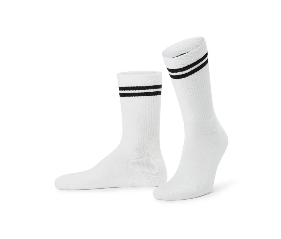 Zwei weiße Socken mit zwei schwarzen Streifen am Bündchen, eine Socke liegt flach, die andere steht aufrecht.