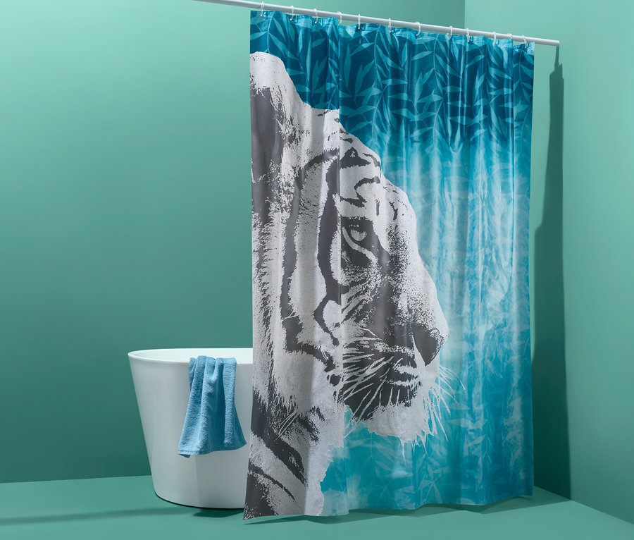 Badewanne mit blauem Handtuch und Duschvorhang mit Tigermotiv.