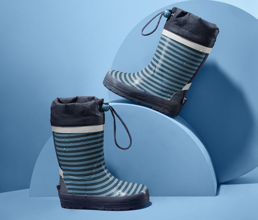 Zwei gestreifte Kinder-Regenstiefel auf blauem Hintergrund.
