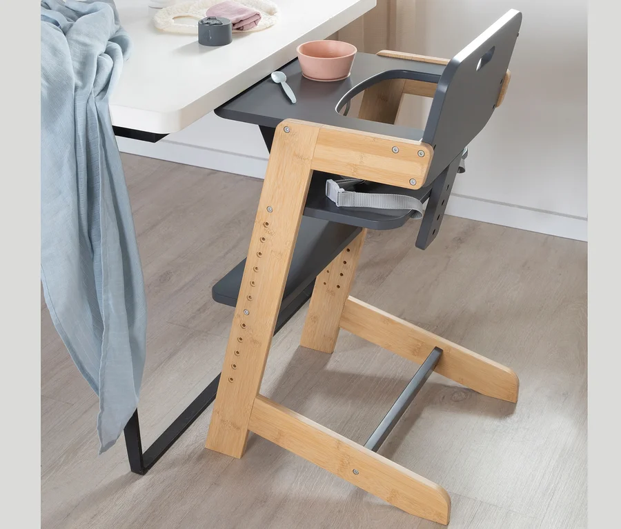 Ein anthrazitfarbener roba Babyhochstuhl steht neben einem Tisch.