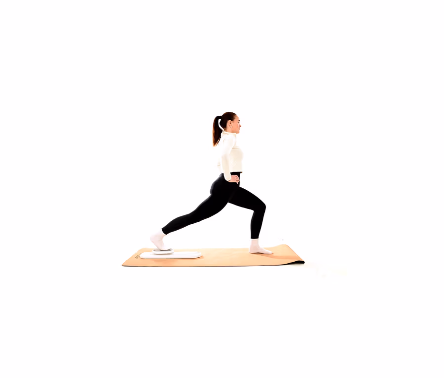 Frau in weißem Oberteil und schwarzen Leggings macht einen Ausfallschritt auf einer Yogamatte, ihr hinterer Fuß steht auf einem weißen Balance Board.