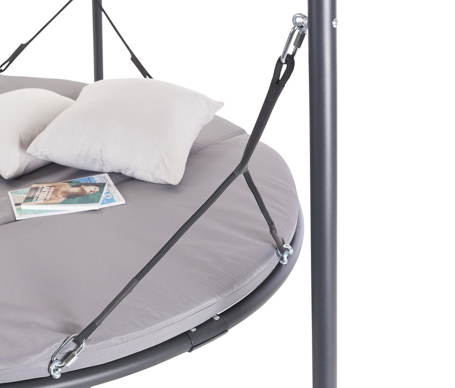 Detailaufnahme einer grauen LECO-Luxusschaukel mit zwei weißen Kissen und Zeitschriften.