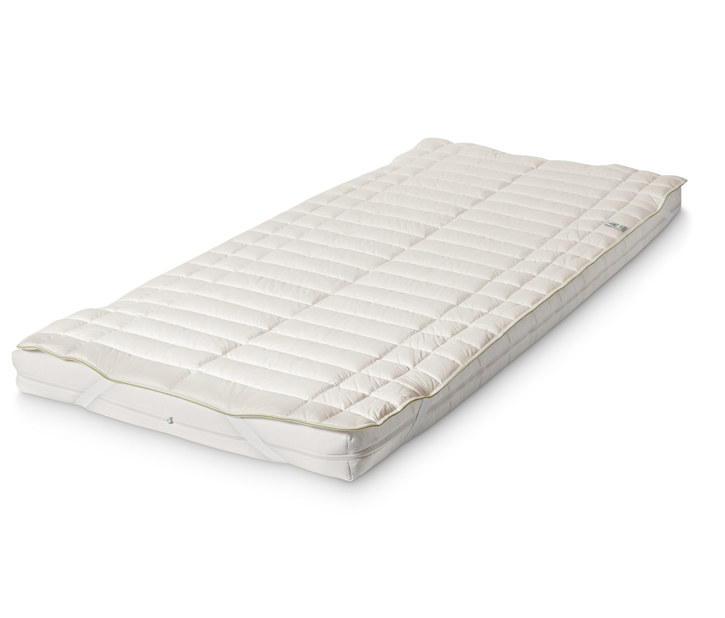 Eine weiße Matratzenauflage mit Schurwolle liegt auf einer Matratze.