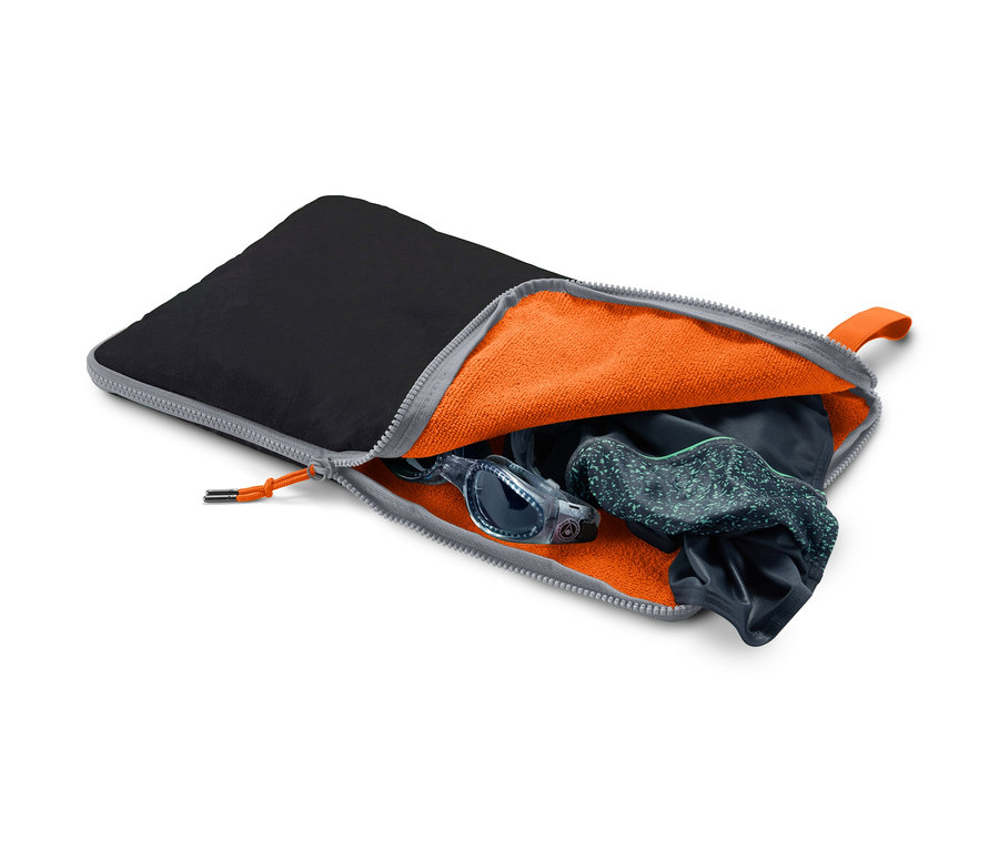 Geöffneter schwarzer 2-in-1: Umziehunterlage und Nasssack mit orangefarbenem Innenraum, in dem sich eine Schwimmbrille und Badebekleidung befinden.