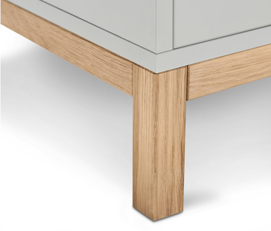 Detailansicht der Unterseite des hellgrauen Waschbecken-Unterschranks "Eklund" mit zwei Schubladen und hellen Holzfüßen.