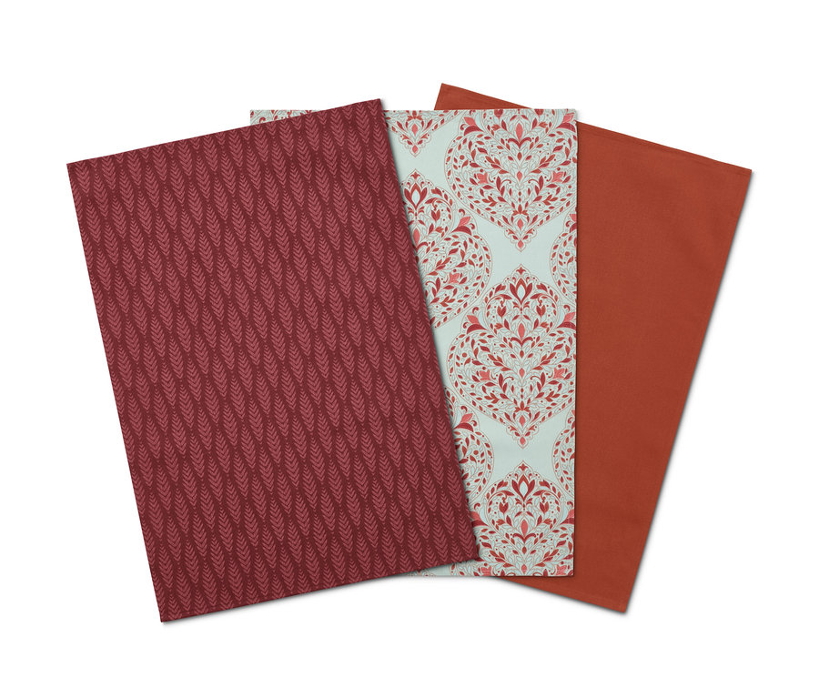 Drei Geschirrtücher: Bordeauxrot mit Muster, Hellblau mit Blumenmuster und Orange.