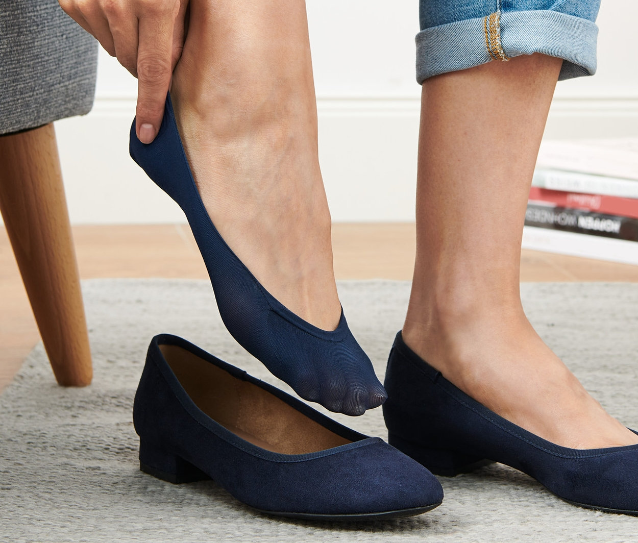 Frau zieht blaue 3 Paar Ballerina-Füßlinge an.