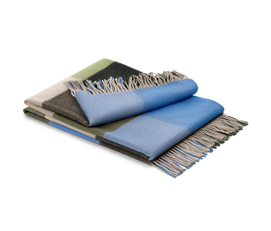 Ein gefaltetes Plaid mit Fransen in Grün, Beige, Braun und Blau.