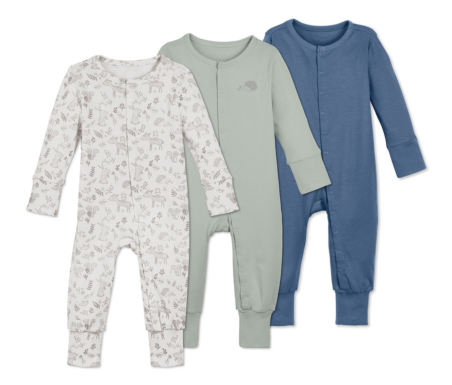 Drei Baumwoll-Pyjamas liegen nebeneinander. Ein Pyjama ist weiß mit Waldtiermuster, einer ist grün und einer blau.