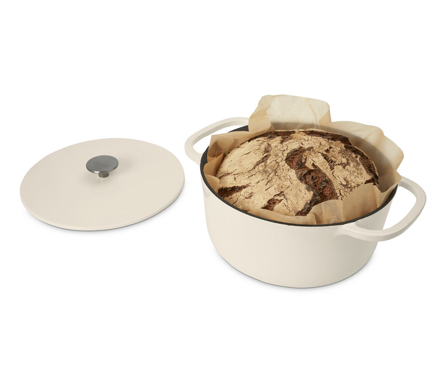 Ein gebackenes Brot in einem cremefarbenen Gusseisen-Bräter.