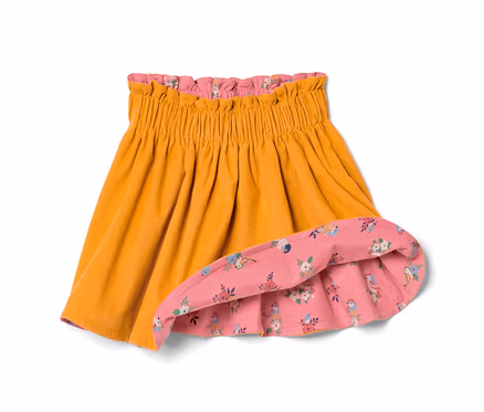 Detailansicht eines Kleinkind-Cord-Wenderocks, goldfarben außen, rosa mit Vogel- und Blumenmuster innen.