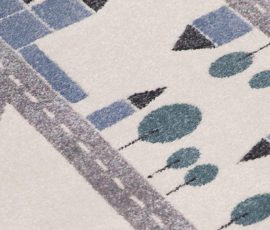 Detailansicht des Kinderteppichs VILLA Streets, ca. 120 x 170 cm, mit Straßen-, Baum- und Gebäudemotiven in Blau und Grau auf beigem Grund.
