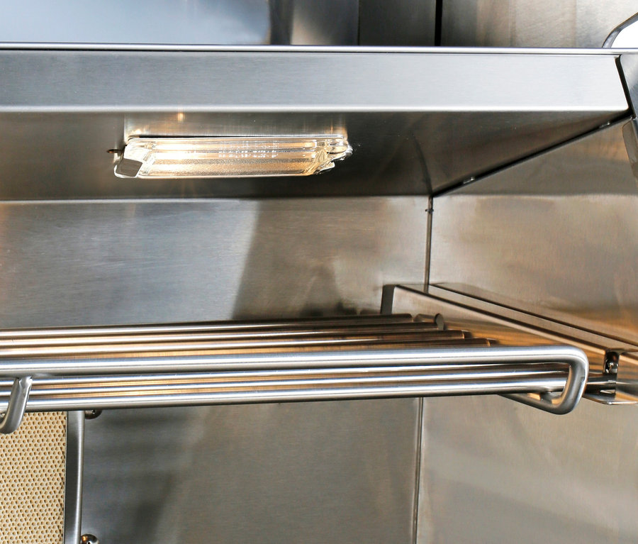 Detailansicht des Innenraums einer Buschbeck Premium Outdoor-Küche mit Grillfunktion aus Edelstahl, beleuchtet durch eine Innenleuchte.