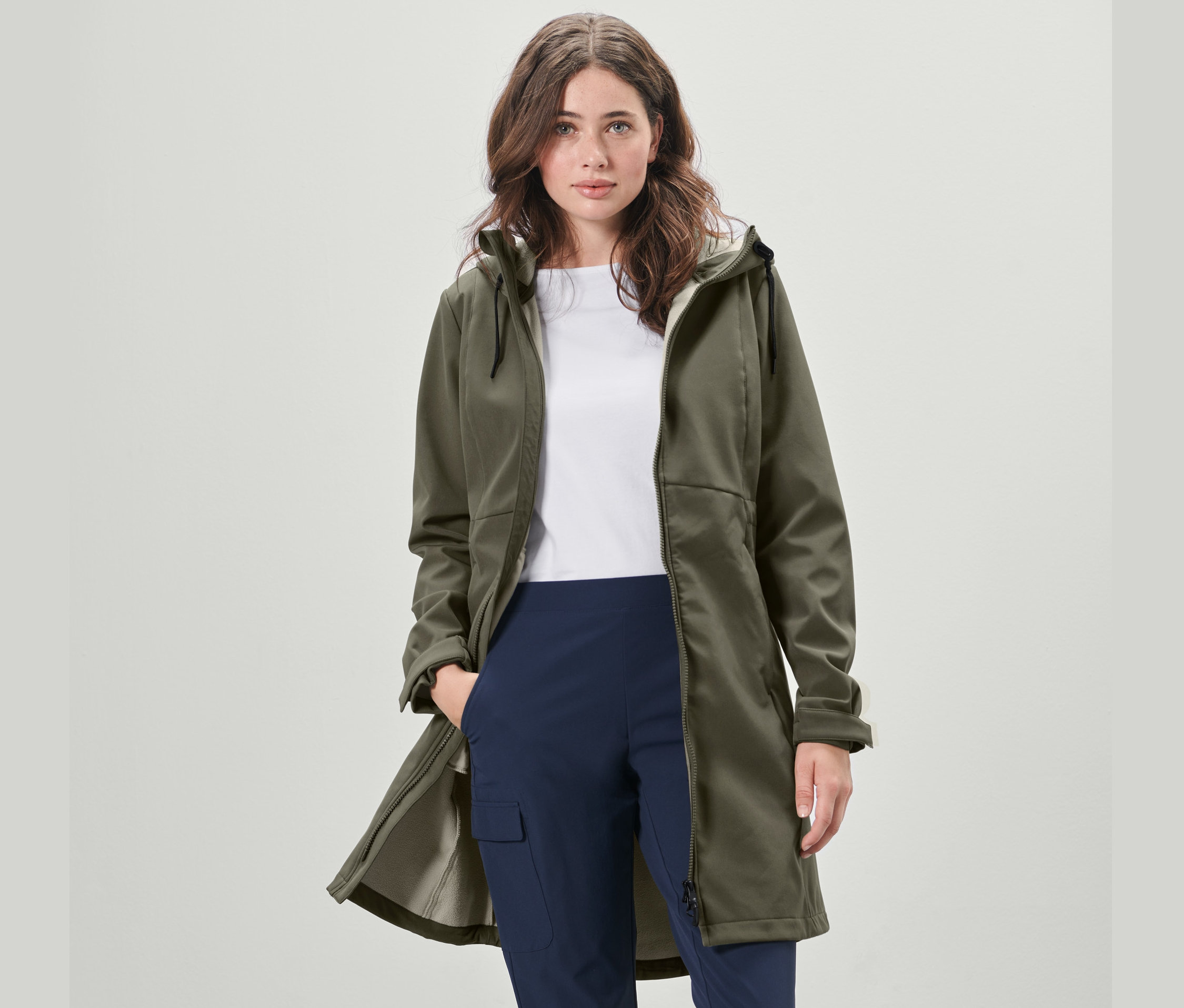 Eine Frau trägt einen khaki Softshellmantel.