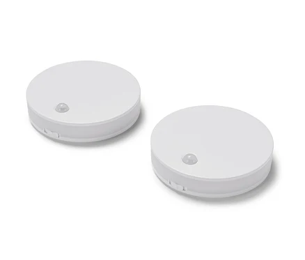 Zwei LED-Multifunktionsleuchten liegen auf einer weißen Oberfläche.