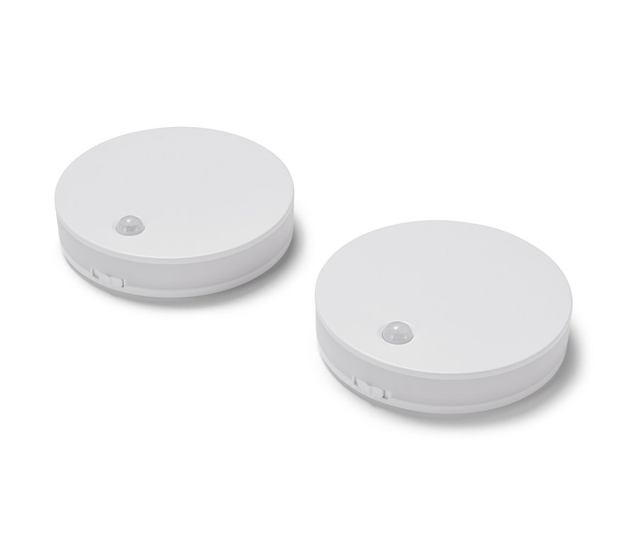 Zwei LED-Multifunktionsleuchten liegen auf einer weißen Oberfläche.