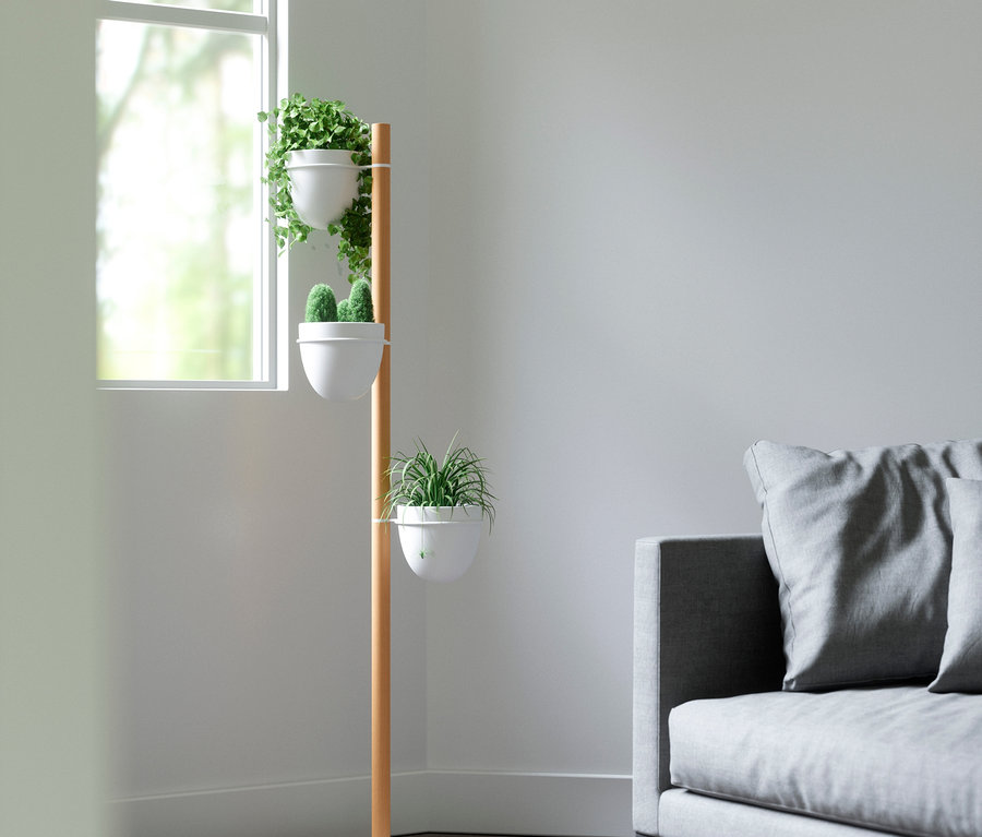 Blumenständer mit Pflanzen steht in einer Ecke des Zimmers neben einem grauen Sofa. Zu sehen ist der Umbra-Blumenständer »Floristand«.