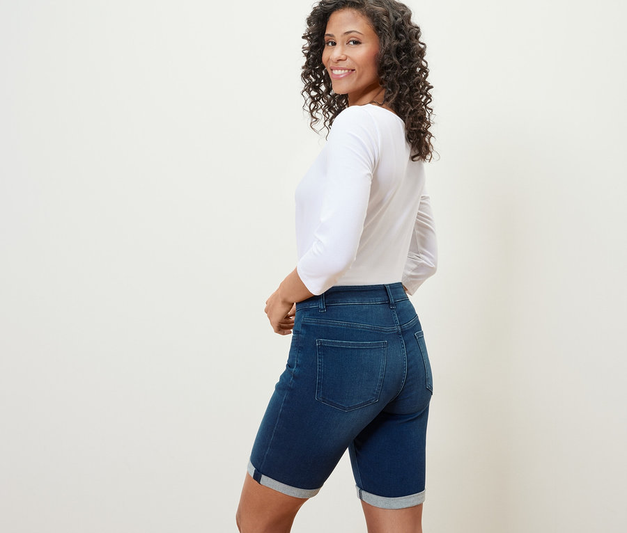 Frau blickt über die Schulter und trägt eine Bermuda-Jeans ‒ Fit »Lea« in Dark Blue Denim.