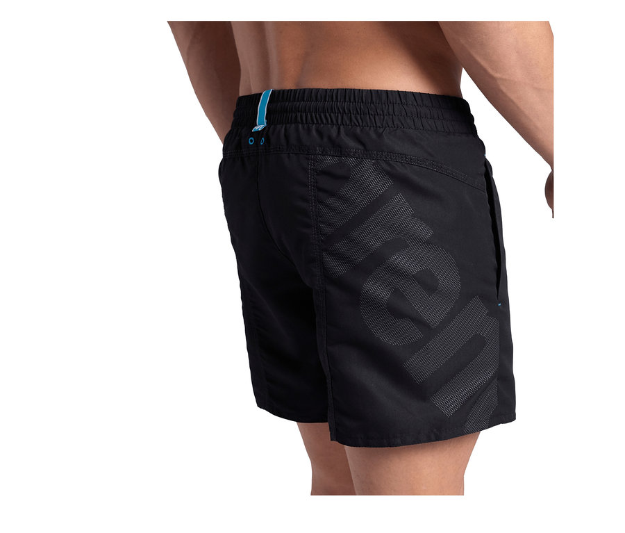 Rückenansicht einer Person, die schwarze arena Pro_File Beach Shorts mit elastischem Bund und großem dunkelgrauem Logo an der Seite trägt.