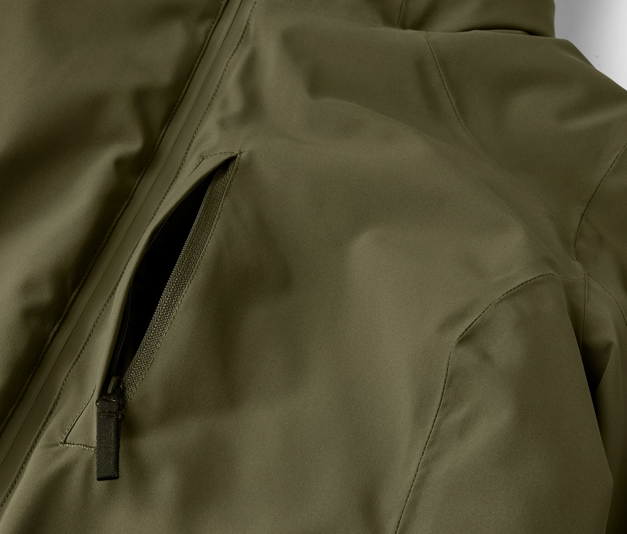 Detailaufnahme einer olivgrünen Jacke mit Reißverschlusstasche.