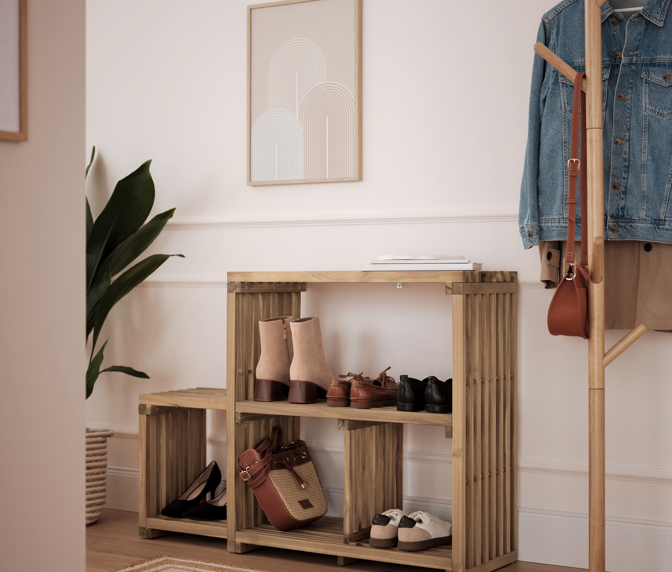 Bambus-Schuhregal mit zwei Ablagen mit Schuhen und Handtasche, daneben steht ein Kleiderständer.