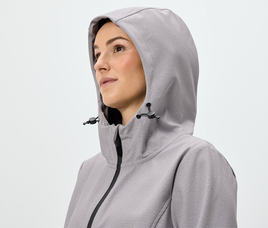 Porträt einer Frau, die eine hellviolette Reissverschlussjacke mit Kapuze trägt.