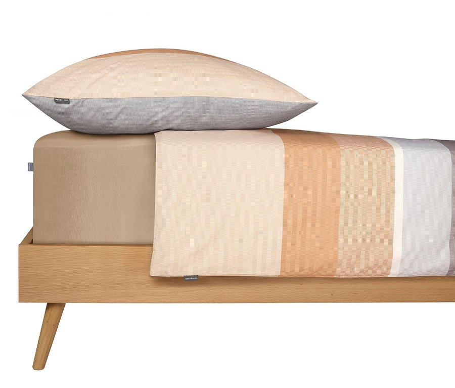 Gestreifte SCHIESSER Renforcé-Bettwäsche »Endy Stripes« in Sandfarbe auf einem Bett.