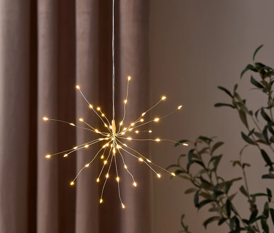 Eine hängende Sternenlicht-Dekoration mit kleinen gelben Lichtern an Drähten.