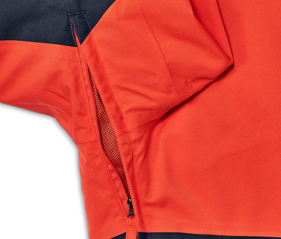 Detailansicht einer rot-blauen Skijacke mit geöffneter Netztasche.